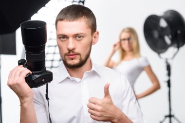 Young male photographer showing thumbs up clipart