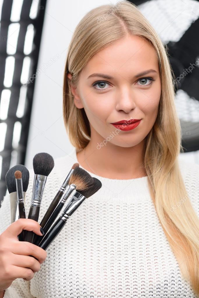 Makeup artist showing professional brushes.