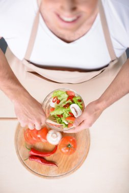 Güçlü adam gülümseyen bir salata karıştırma.