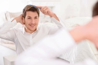 Genç adam onun saç tarama meşgul.