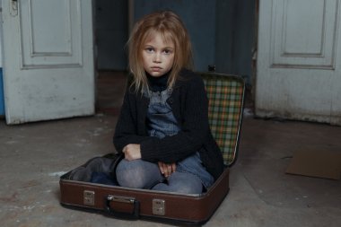 Bavulun içinde oturan depresif kız