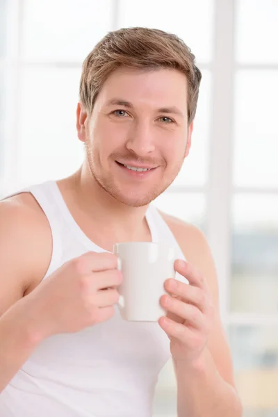 Jonge kerel geniet zijn kopje koffie. — Stockfoto