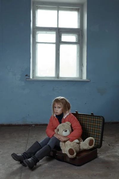 Lonely girl sitting on the suitcase — Stock Photo, Image