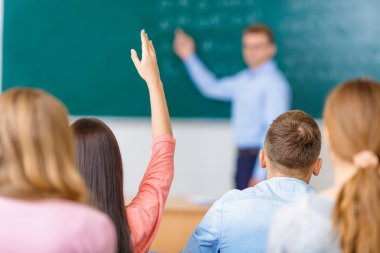 One of students raises arm to answer the question.