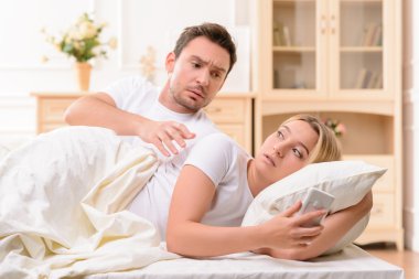 Husband and wife lying in bed clipart
