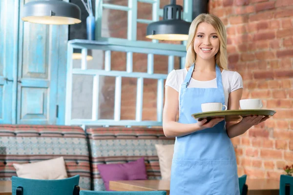 Pleasant waitress holding tray — Stockfoto