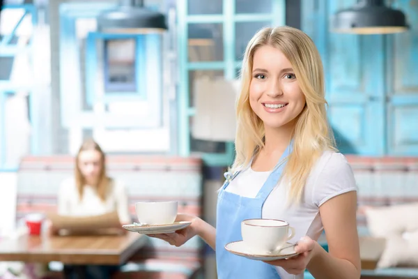 Angenehme Kellnerin mit Tasse — Stockfoto