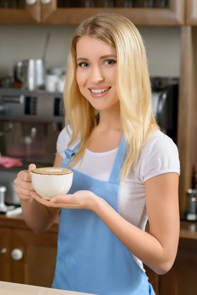 Pleasant waitress standing at a counter — Stock Photo, Image