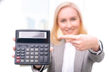 Pleasant businesswoman holding calculator