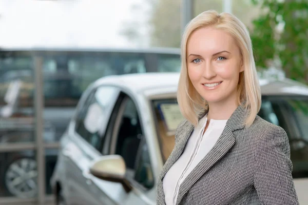 Cliente feminino está de pé na frente de um carro . — Fotografia de Stock