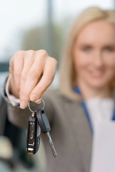 Saleswomans hand greppa bilnycklarna. — Stockfoto