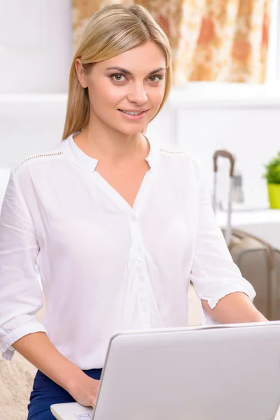 Aantrekkelijke hotel resident werken op haar laptop. — Stockfoto