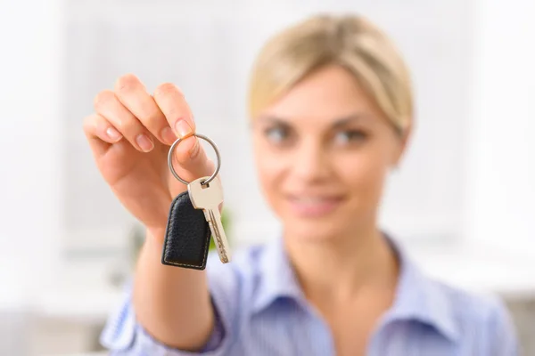 Young woman upholding room key.