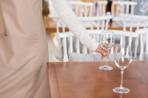 Официантка ставит стаканы с водой на столы . — стоковое фото