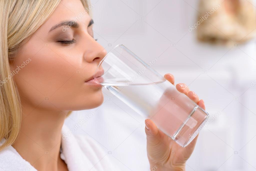 Young lady drinking water.