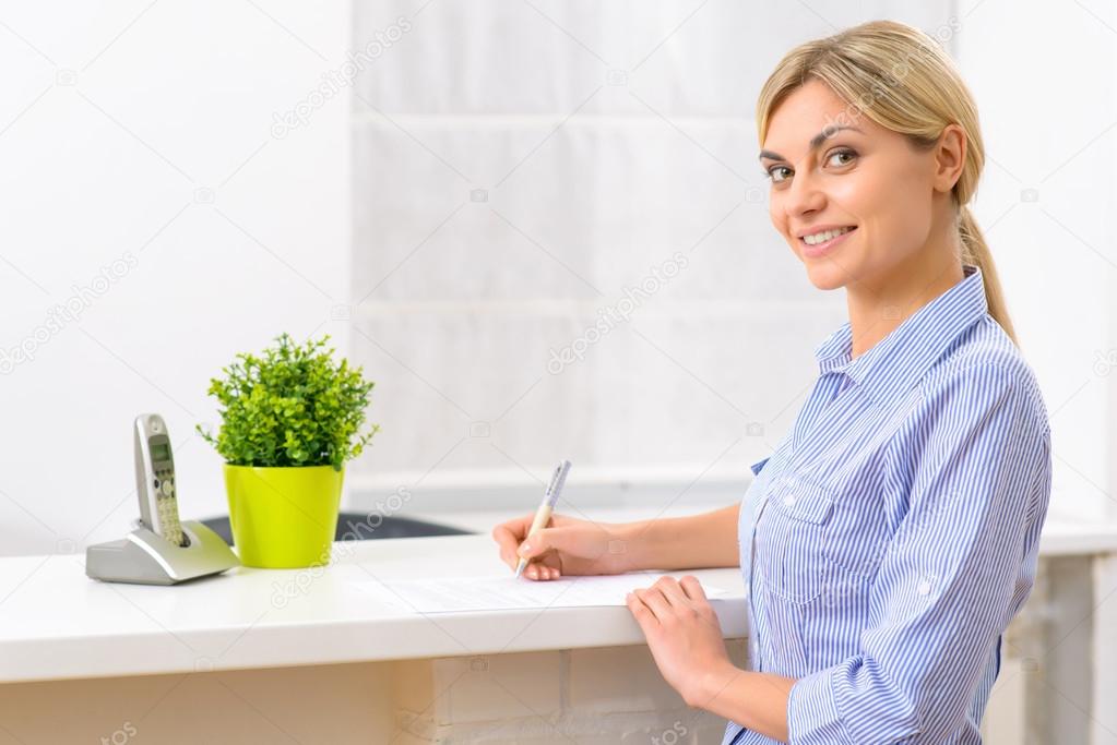 Young lady filling out hotel papers.