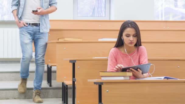 Sonriente joven mira a su compañero de clase pasar por delante de ella . — Vídeo de stock