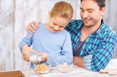 Positive father and daughter having breakfast