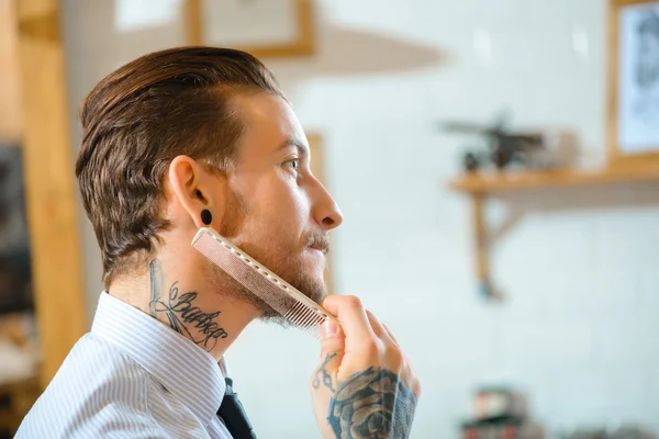 Professional barber brushing his beard — Stock Photo, Image