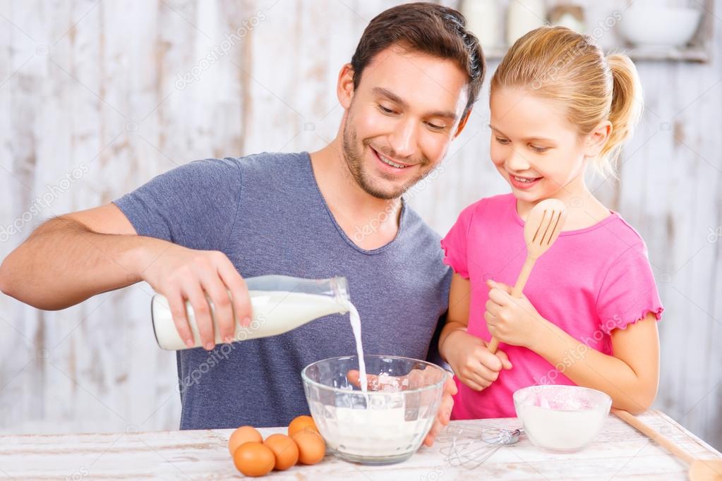 Happy father and daughter baking together