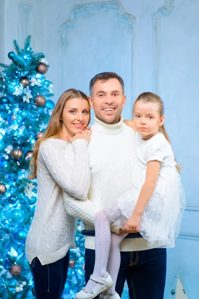 Glückliche Familie, die am Weihnachtsbaum steht — Stockfoto