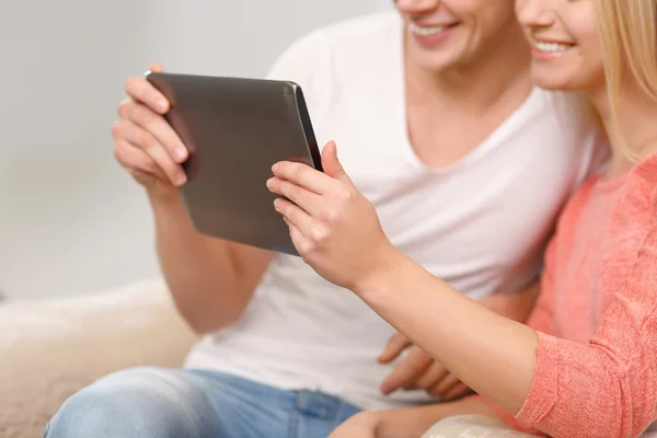 Jonge glimlachend paar met behulp van tablet. — Stockfoto