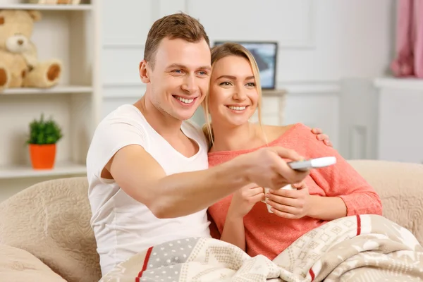 Jeune couple souriant regarder la télévision — Photo