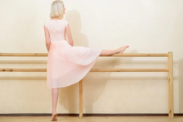 Jonge vrouw die zich uitstrekt in het klaslokaal dansen. — Stockfoto