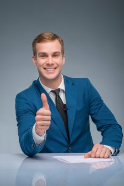 Smiling newscaster showing thumbs up. clipart