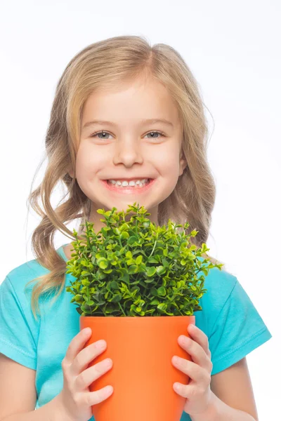 Sonriente niña sosteniendo una planta verde . —  Fotos de Stock