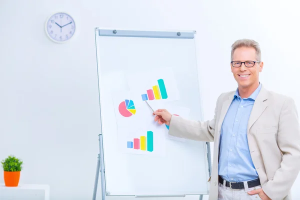 Hombre de negocios sonriente trabajando con gráficos . — Foto de Stock