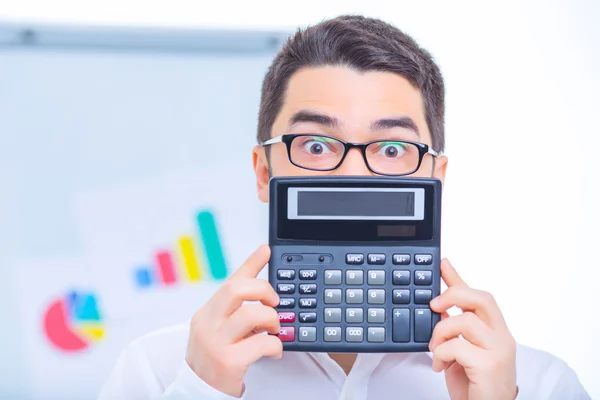 Jovem empresário defendendo uma calculadora . — Fotografia de Stock