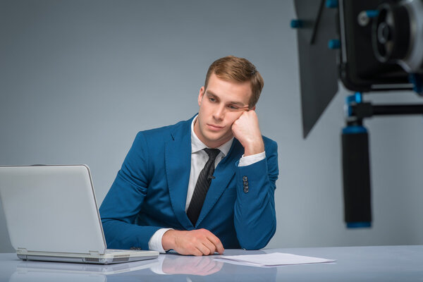 Newsman looking bored and weary.