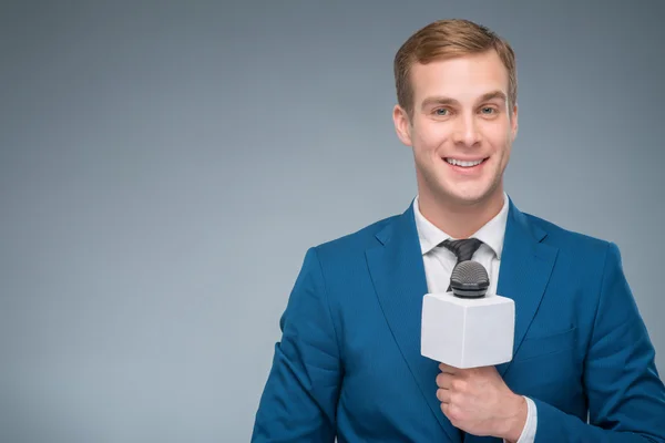 Periodista sonriente sosteniendo un micrófono . —  Fotos de Stock