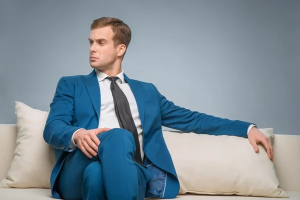 Schöner Mann sitzt auf dem Sofa. — Stockfoto