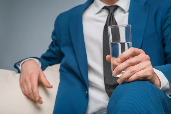 Knappe man met een glas water. — Stockfoto