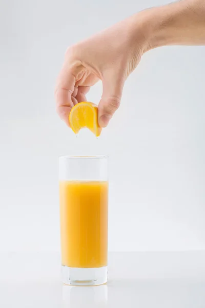 Human hand squeezing orange juice — Stock Photo, Image