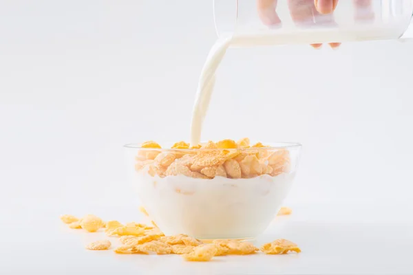 Se vierte leche en un tazón de copos de maíz . — Foto de Stock