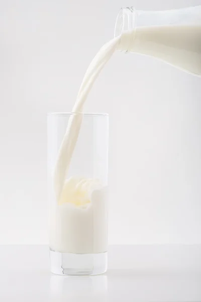 La leche está siendo vertida en el vaso . — Foto de Stock