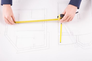 Male hands scaling a project drawing. clipart