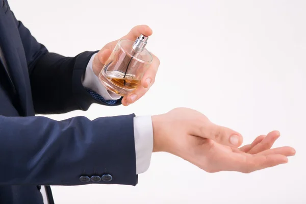 Mężczyzna rozpylania perfum na nadgarstek. — Zdjęcie stockowe