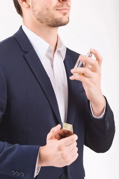 Homem pulverizando perfume sobre si mesmo . — Fotografia de Stock