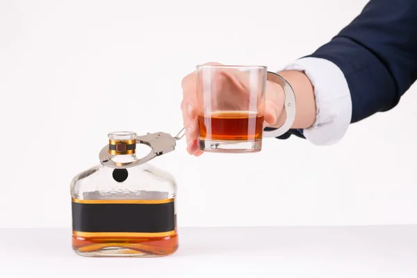 Male hand chained to bottle of liquor. — Stock Photo, Image
