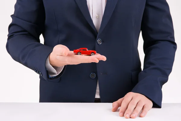 Homem segurando pequena cópia do carro vintage . — Fotografia de Stock