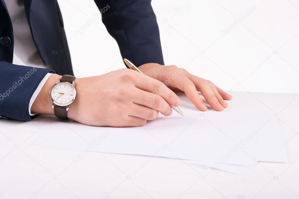 Businessperson writing on paper.