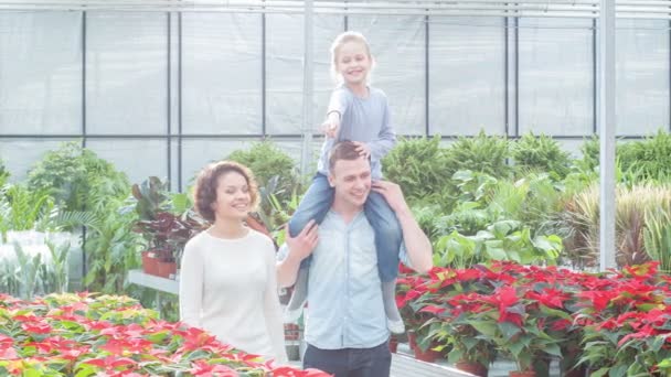 Mladá rodina výběru květiny ve skleníku.
