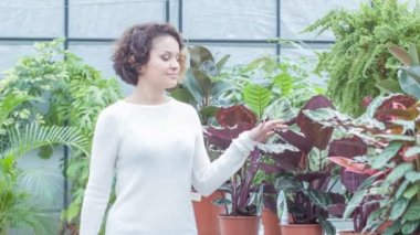 Genç kadın bir gülümseme ile çiçek izlerken.