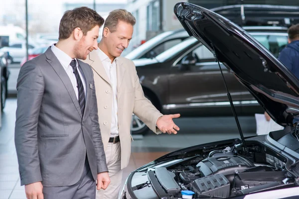 Sale assistant showing the car — Stock Photo, Image