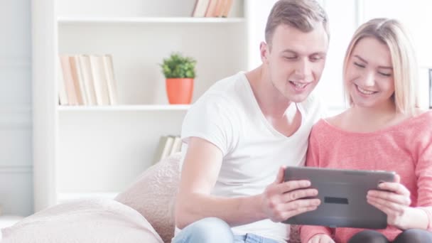 年轻人微笑着对夫妇使用平板电脑. — 图库视频影像