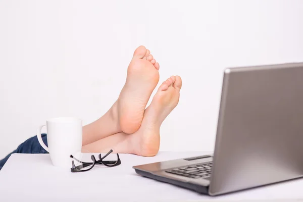 Relaxed person holding legs on the table — Stock Photo, Image
